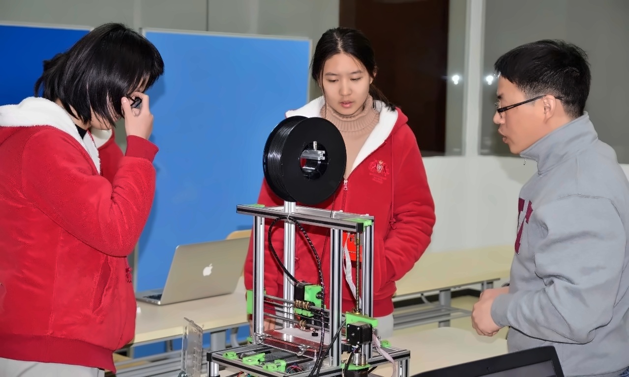 高老师指导学生了解3D打印机原理.jpg