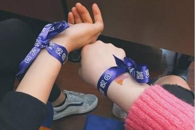 志愿者为我们系上带有展翼家园的蓝色丝带